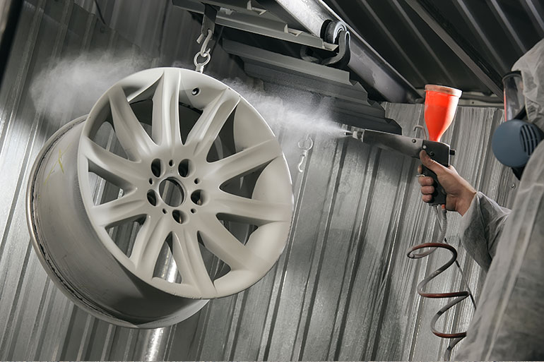 technician spraying an alloy wheel
